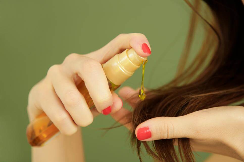 person applying Hair Oils hair salon Toujours Belle